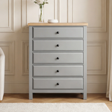 [Grey] Haven tall chest of drawers in a panelled room with a glass vase of dried flowers placed on the oak top