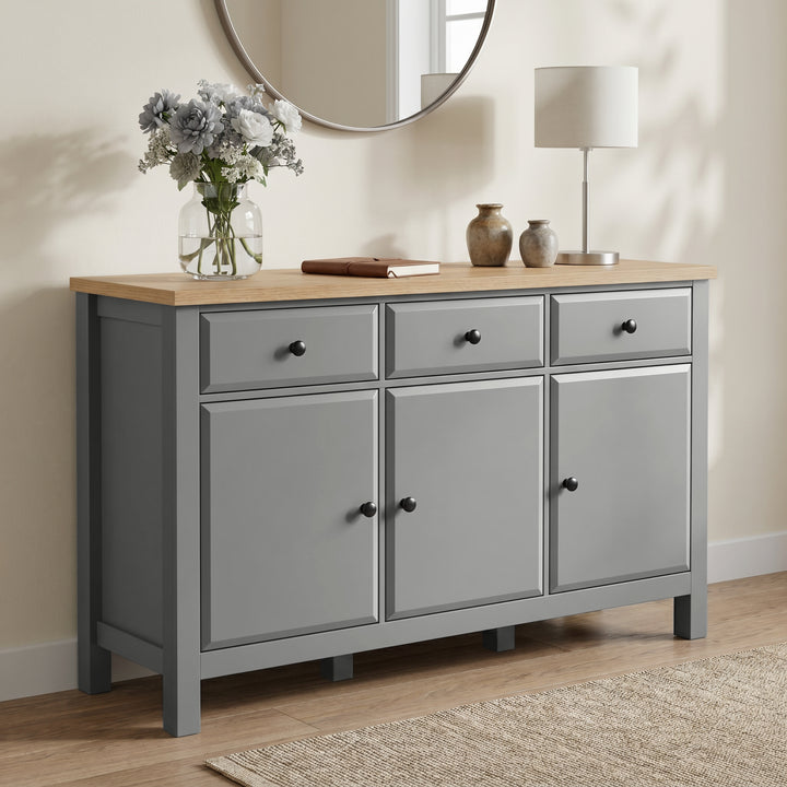 [Grey] Haven Large Black Sideboard with Drawers & Oak Top shown from a low angle in a living room.