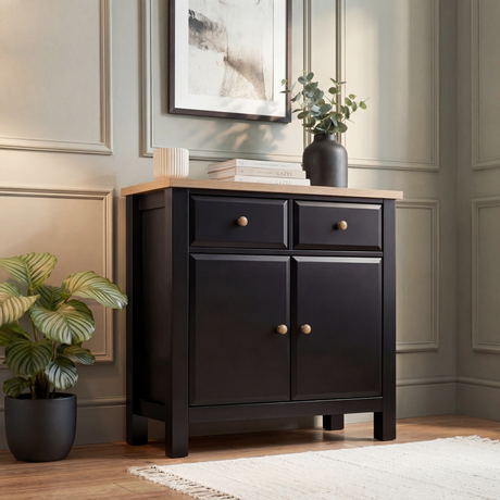 [Black] Haven sideboard front-angle lifestyle with vase and books on oak top, 2 drawers and 2 doors, round knobs