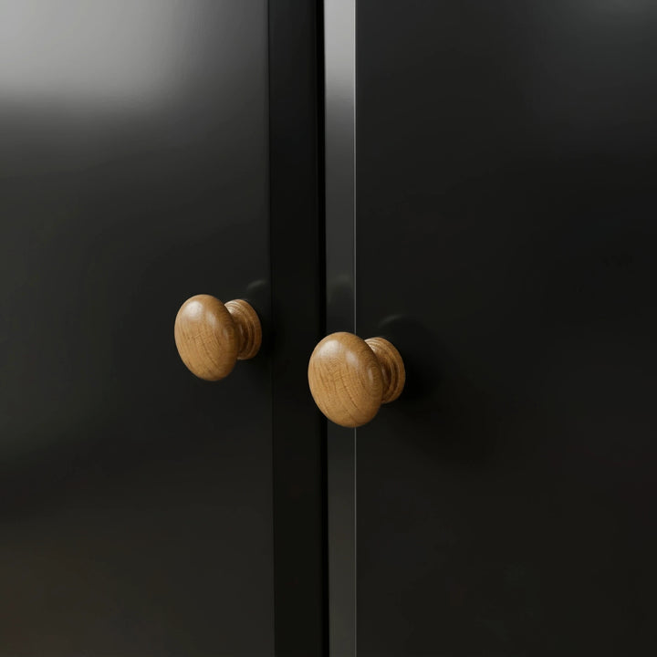 [Black] Pair of round oak knobs on the Haven 2 door wardrobe where the two black doors meet.