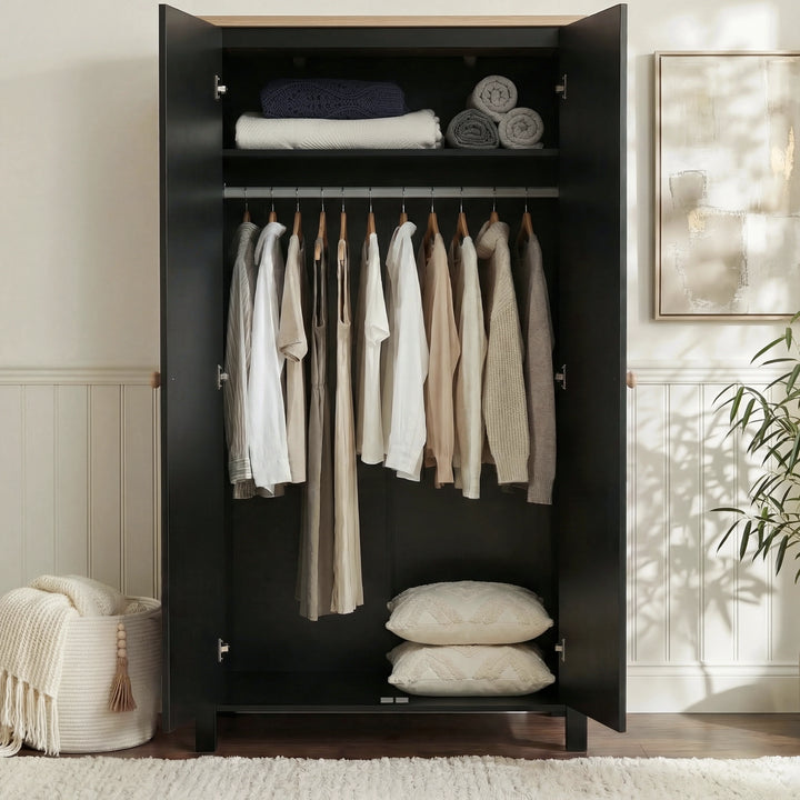 [Black] Haven wardrobe doors open, black interior with rail of shirts and folded linens on shelf above.