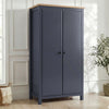 [Blue] Haven wardrobe angled in a bright room, blue painted 2 door frame with warm oak top and round black knobs