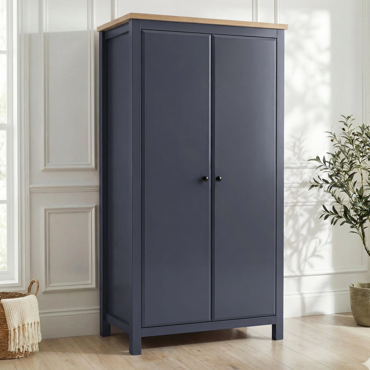 [Blue] Haven wardrobe angled in a bright room, blue painted 2 door frame with warm oak top and round black knobs