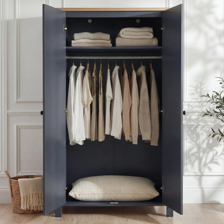 [Blue] Haven wardrobe open, blue painted interior with hanging rail of shirts and folded items on upper shelf