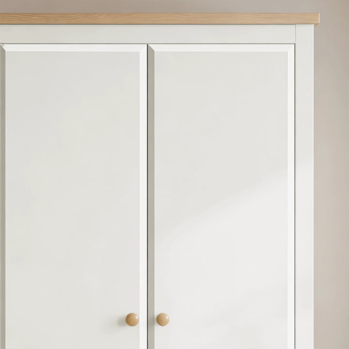 [White] Haven 2 door wardrobe close up of the oak top strip, white door fronts and round wooden knobs below