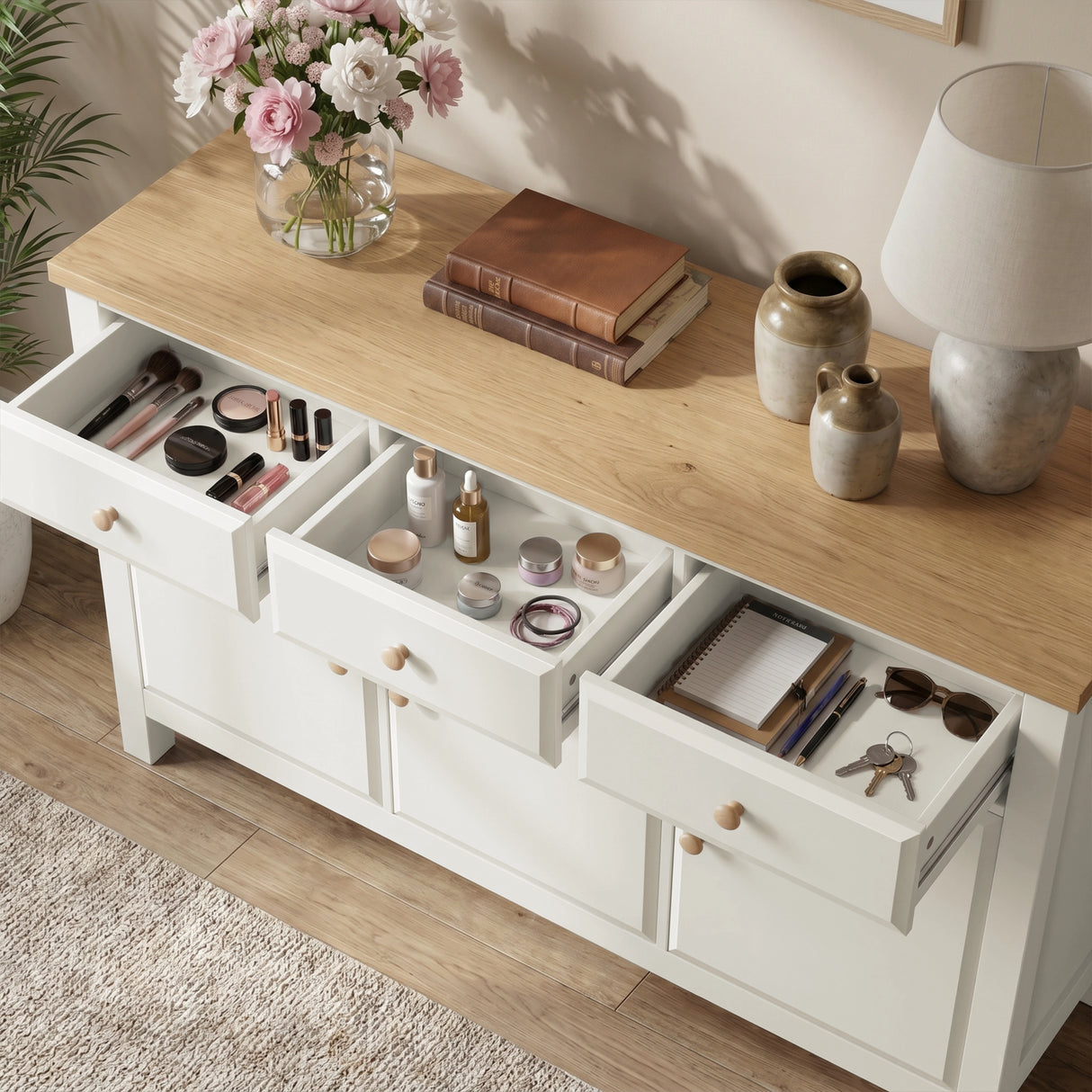 [White] 3 door cupboard with open drawers containing makeup, books, and other items on a wooden surface