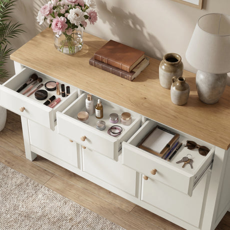 [White] 3 door cupboard with open drawers containing makeup, books, and other items on a wooden surface