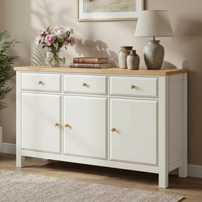 [White] sideboard with wooden top in a room setting with decor items