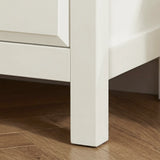 [White] Haven 3-drawer chest angled close-up showing painted frame leg detail and base against a wooden floor