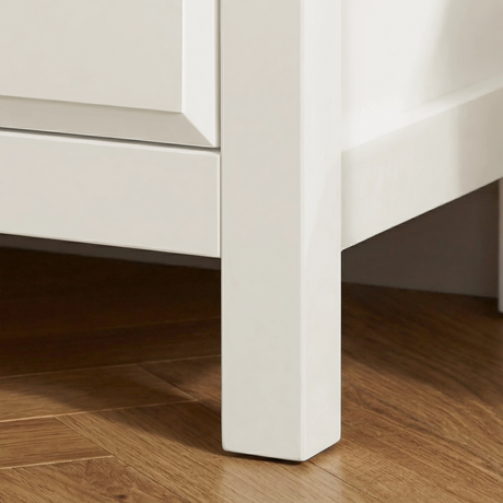 [White] Haven 3-drawer chest angled close-up showing painted frame leg detail and base against a wooden floor