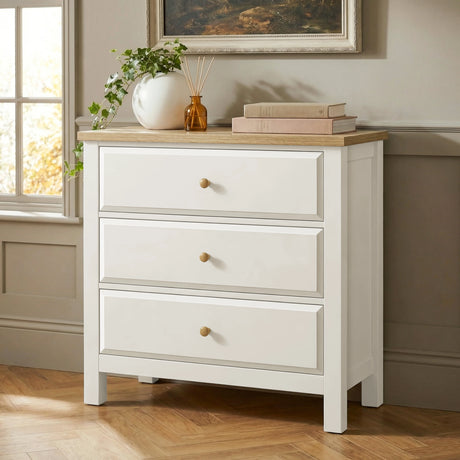 [White] Haven 3-drawer chest front view beside a window with plant and stacked books on oak veneer top