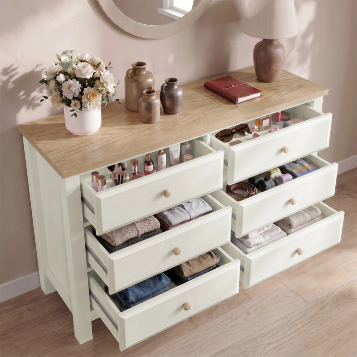 [White] dresser with open drawers containing various items, on a wooden floor