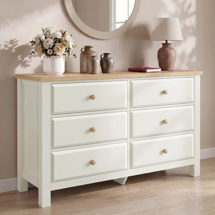 [White] 6 drawers dresser with wooden top against a beige wall with decorative items