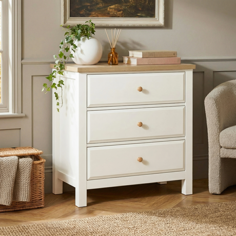[White] Haven 3-drawer chest in a bedroom with framed artwork above and decorative accessories on oak veneer top