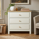 [White] Haven 3-drawer chest front view in a room with armchair, wicker basket and decorative items on oak top
