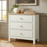 [White] Haven 3-drawer chest front view beside a window with plant and stacked books on oak veneer top