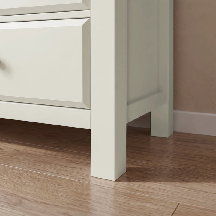 [White] Close-up of a white 6 chest of drawers cabinet corner on a wooden floor with a neutral wall background