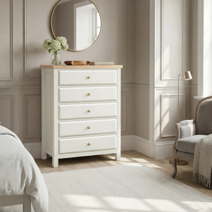[White] Haven 5-drawer tall chest in a bedroom setting with round mirror and soft furnishings in the background