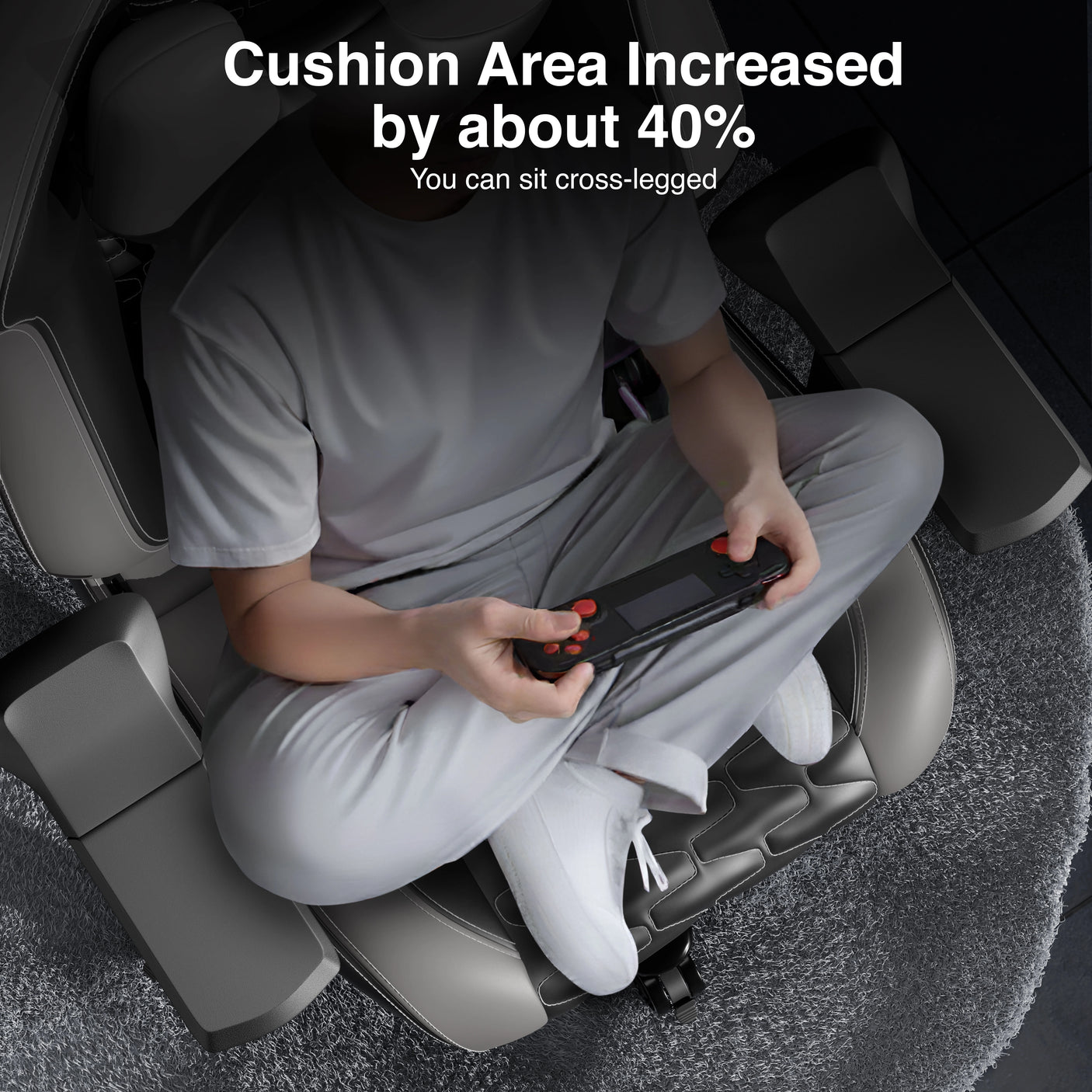Person sitting on a massage chair with increased cushion area, holding a remote control.