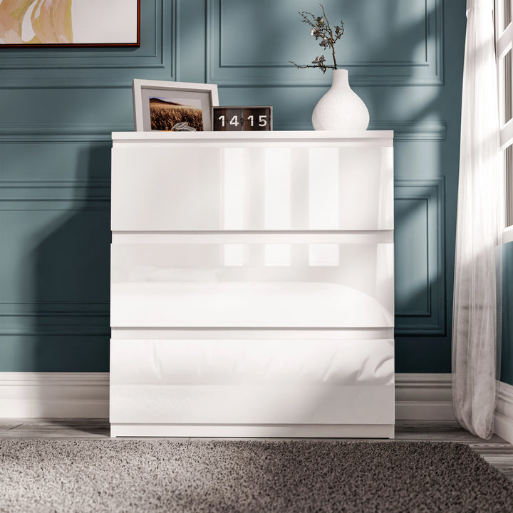 [White] high gloss 3 drawer chest straight-on view with framed photo and stems styled above on dark teal wall