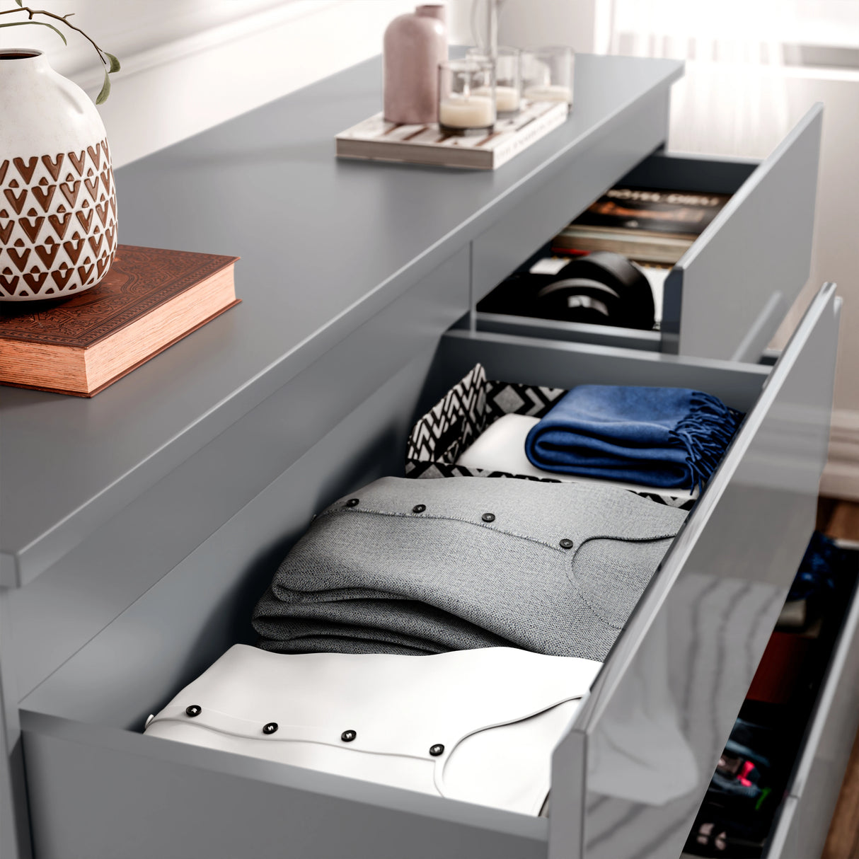 High Gloss Wide 8 Drawer Chest of Drawers in grey with open drawers showing folded clothes and accessories. Ideal bedroom dresser for modern storage.