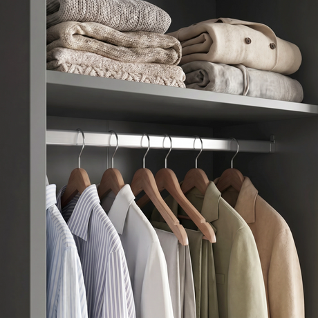 [High Gloss Grey] Torvek wardrobe interior close-up of chrome hanging rail with jackets and upper shelf with folded knits