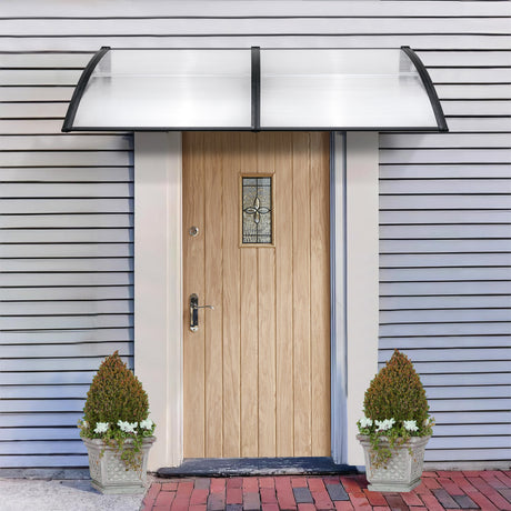 House front door canopy with clear polycarbonate sheet and black brackets for weather protection.