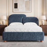 [King | Blue] bed with gently split curved headboard and layered pillows arranged against a panelled wall