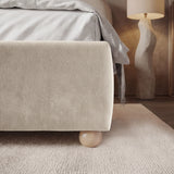 [King | Beige] Corner side detail of beige king bed frame emphasizing soft fabric texture of footboard and wooden legs
