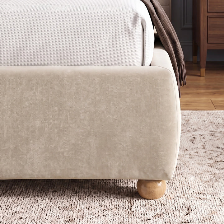 [King | Beige] Corner side detail of beige king bed frame emphasizing soft fabric texture of footboard and wooden legs