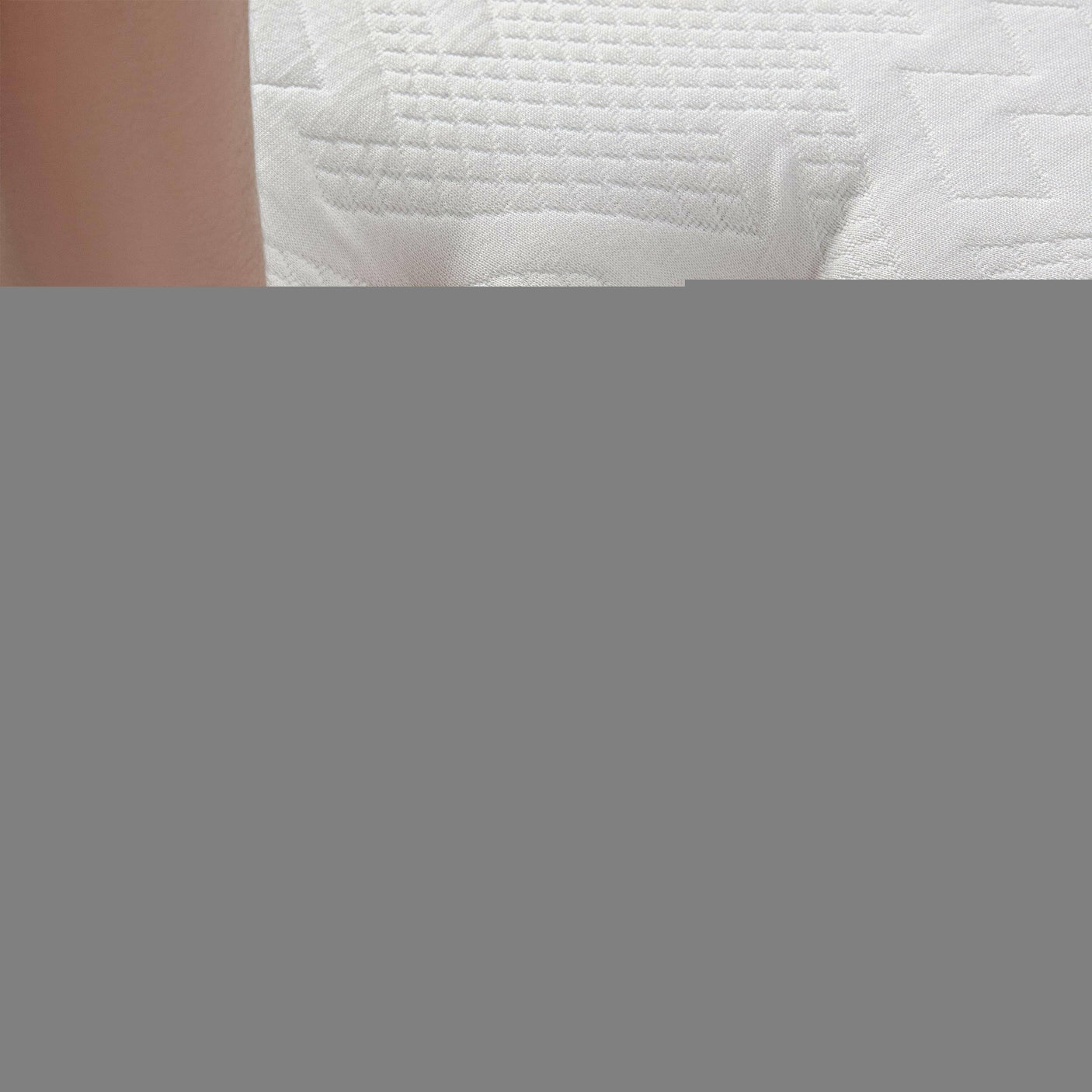 Hand pressing on a king mattress size to demonstrate its softness and responsive memory foam.