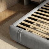 Interior wood support system with evenly spaced slats inside an upholstered king grey bed frame 