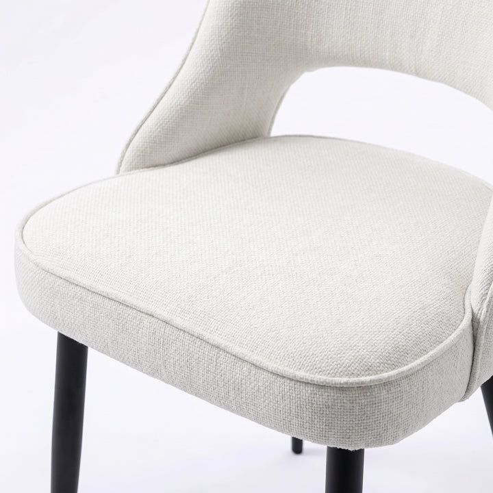 [Cream | Clear] Close-up of Kyvon 4-seater cream upholstered fabric comfy curve chair seat with black metal legs