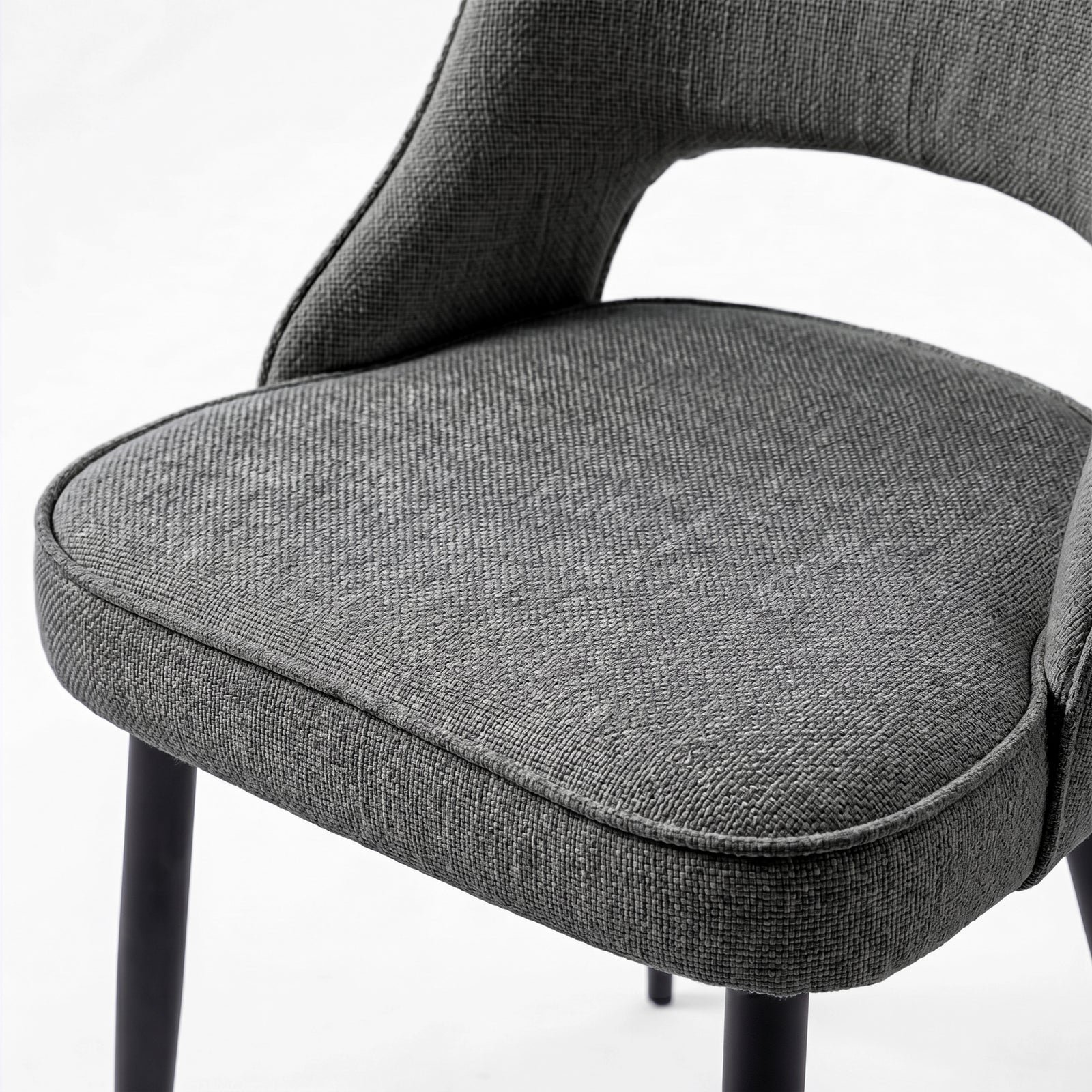 [Grey | Clear] Close-up of Kyvon 4-seater grey upholstered fabric comfy curve chair seat with black metal legs