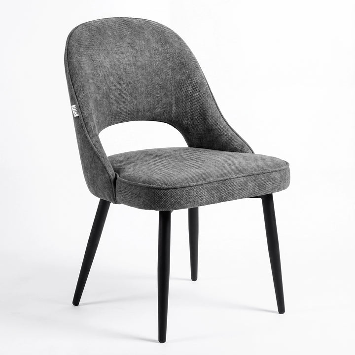 [Grey | Tinted] Kyvon grey upholstered fabric comfy dining chair angled view with black metal legs