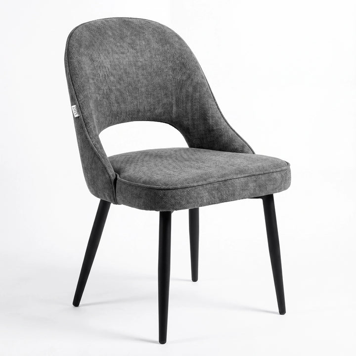 [Grey | Tinted] Kyvon grey upholstered fabric comfy dining chair angled view with black metal legs