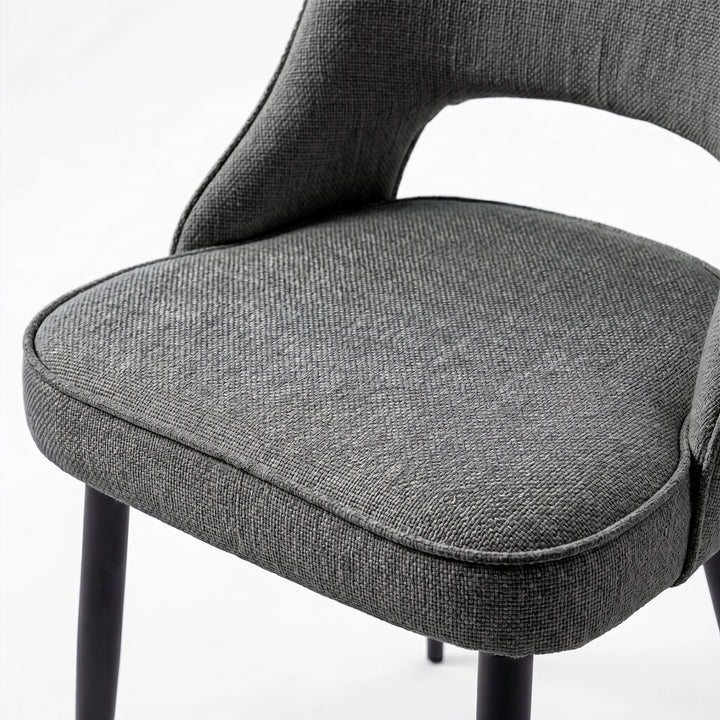 [Grey | Tinted] Close-up of the 4 seater Kyvon grey upholstered fabric comfy chair seat with black metal legs