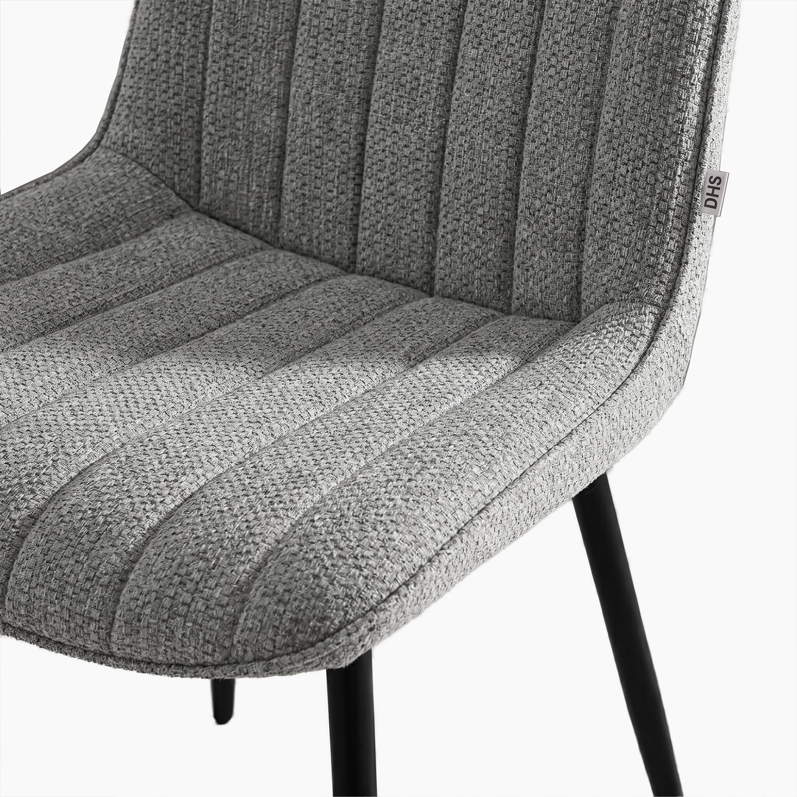 [Vertical Grey | Clear] Close-up of Kyvon grey upholstered fabric channeled stitched chair seat with black metal legs