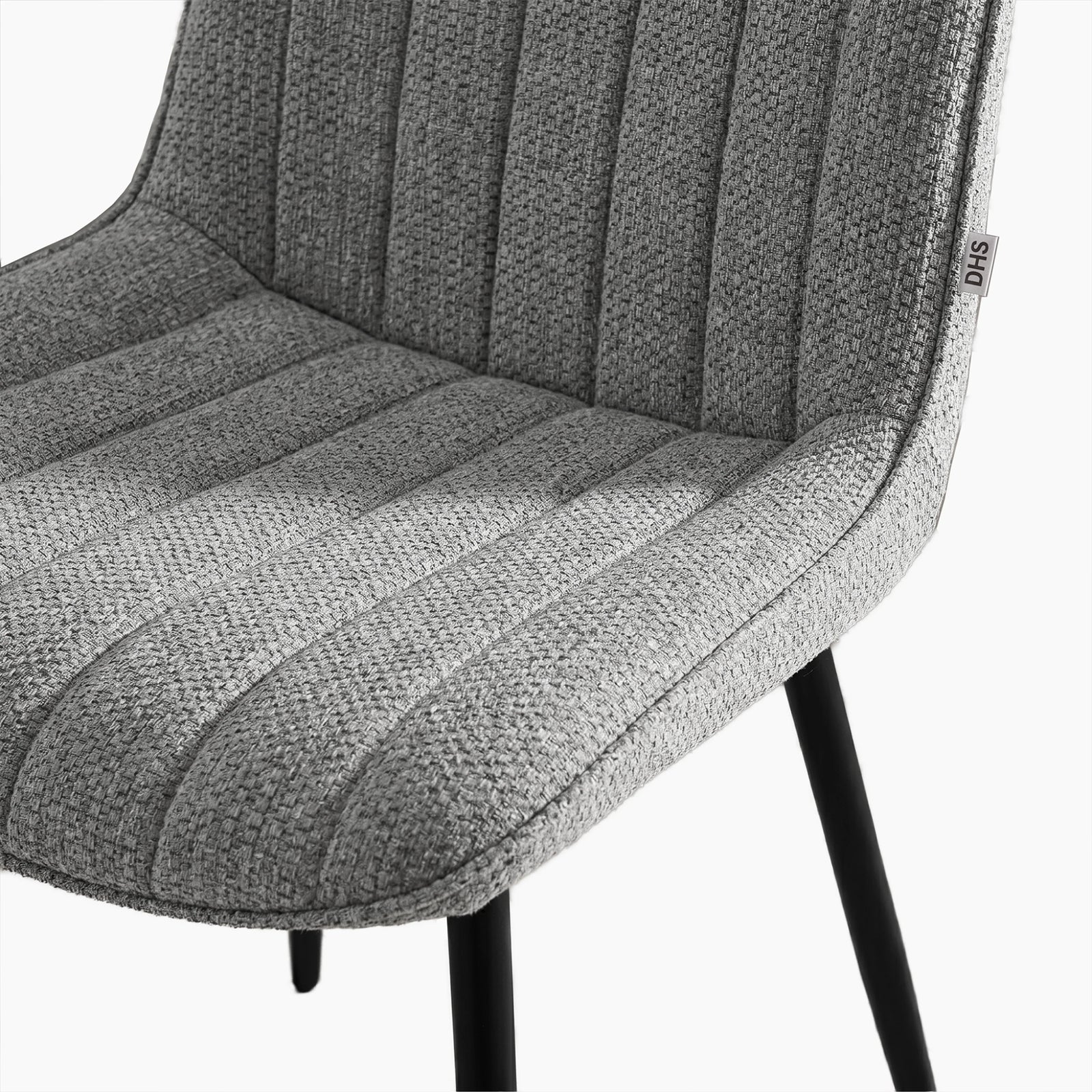 [Vertical Grey | Clear] Close-up of Kyvon grey upholstered fabric channeled stitched chair seat with black metal legs