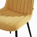 [Vertical Mustard | Clear] Close-up of Kyvon mustard upholstered fabric channeled stitched chair seat with black metal legs