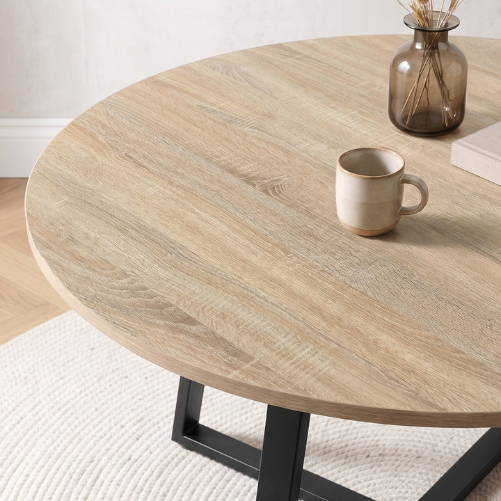 [Grey | Sonoma Oak] Close-up of Kyvon round dining table set's sonoma oak-effect tabletop and black base