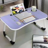 Laptop on table with a purple surface featuring a cute cartoon design, foldable white legs.