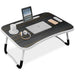 Laptop on tables with tablet slot, cup holder, and striped wooden finish design.