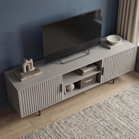 Large grey TV stand with a wide surface and vertical fluted doors, ideal for supporting big screens in modern lounges.