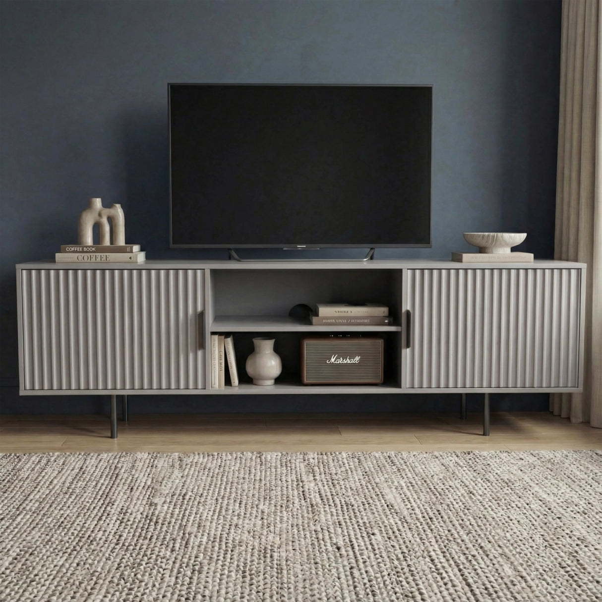 Modern grey TV unit with vertical fluted doors and open shelving, providing a sleek storage solution for contemporary homes