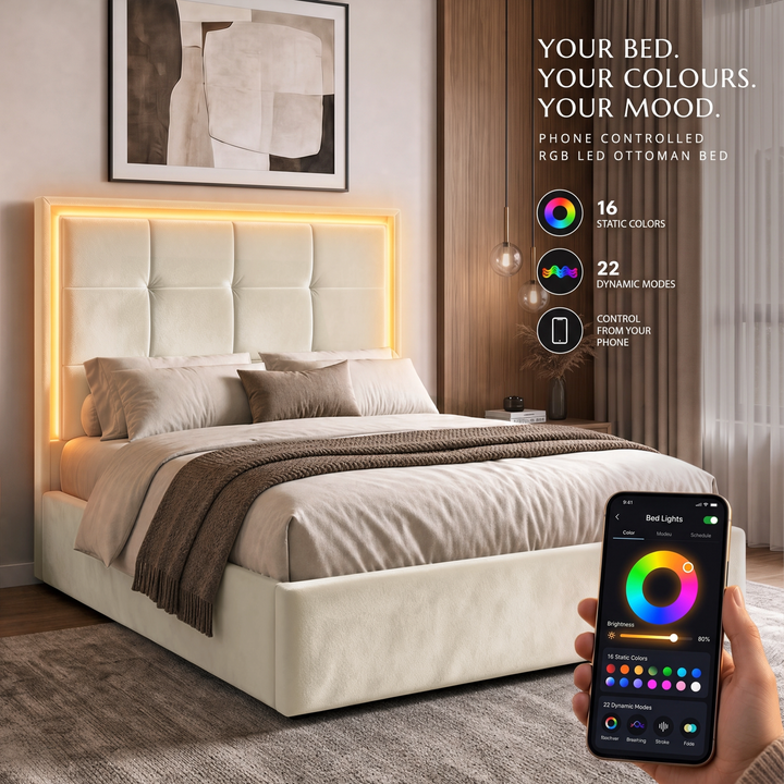 [Beige | Double] bedroom scene shows a light grey upholstered bed with a glowing LED headboard and a hand holding a smartphone that displays the app controlling the bed lights.