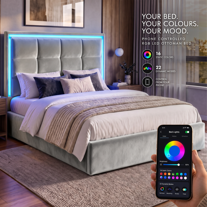 [Light Grey | King] bedroom scene shows a light grey upholstered bed with a glowing LED headboard and a hand holding a smartphone that displays the app controlling the bed lights.