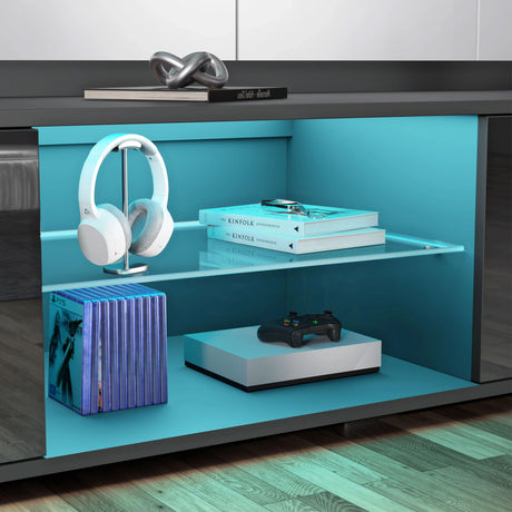 Blue light with electronic items including headphones and books on a wooden floor.