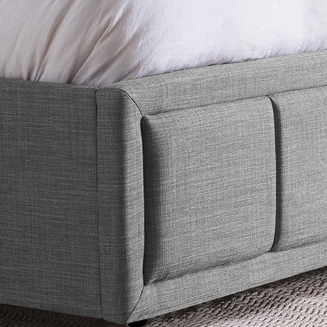 Close-up of a grey fabric upholstered ottoman bed frame with detailed stitching.