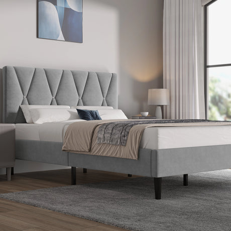 Gray upholstered bed in a modern bedroom with a lamp and abstract painting.